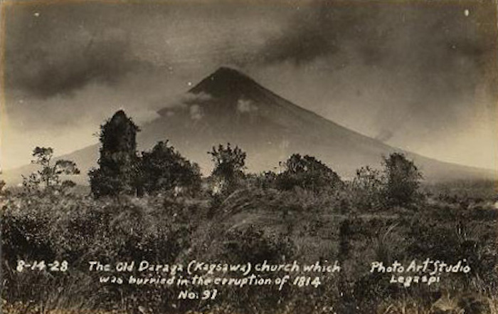1928 photo of the Cagsawa ruins with parts of the facade still intact. The Mayon volcano is seen in the background.