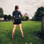 Woman Working Out With Resistance Band In The Park