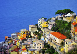 The road passes right above Riomaggiore with its mostly yellow pastel houses that lead all the way down to the narrow harbor where you'll find multi-colored boats bobbing up and down on the azure waters.