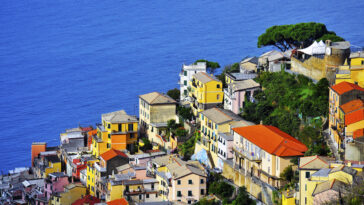 The road passes right above Riomaggiore with its mostly yellow pastel houses that lead all the way down to the narrow harbor where you'll find multi-colored boats bobbing up and down on the azure waters.