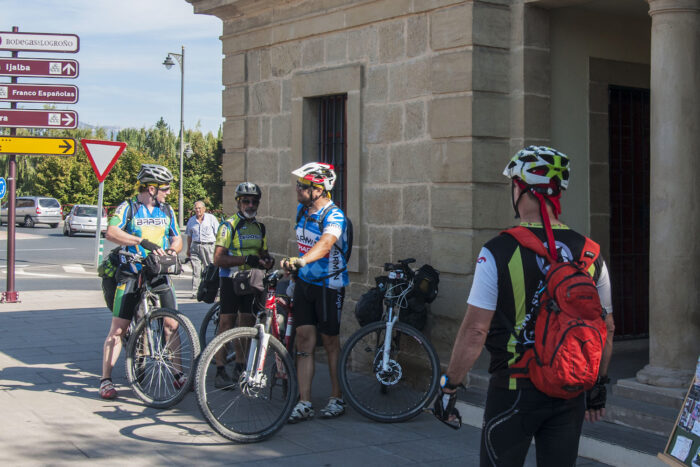 Cyclists from South America check their gear at the info station before crossing the bridge in Logrono.