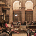 Attending the Pilgrim's Mass held daily at 12:00 noon.