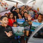 Passengers and crew happily waving onboard AK590