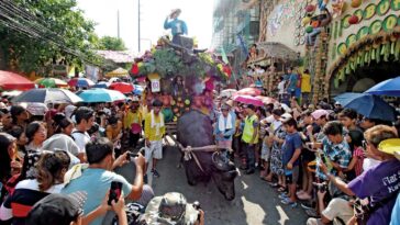 Kneeling Carabao in front of Festival goers