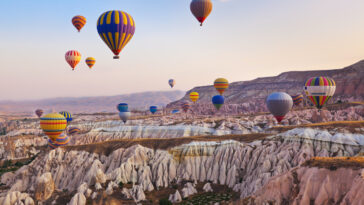 Hot air balloon flying over Cappadocia Turkey photo via Depositphotos