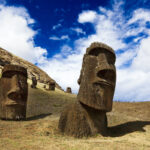 Heads of buried moais standing on a mountain in Easter Island photo via DepositPhotos