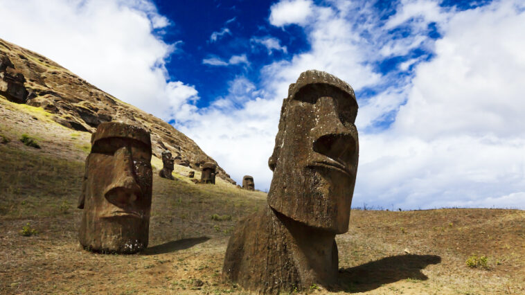 Heads of buried moais standing on a mountain in Easter Island photo via DepositPhotos