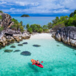 Aerial drone view of in kayak in crystal clear lagoon sea water during summer day near Koh Lipe island in Thailand photo via Depositphotos
