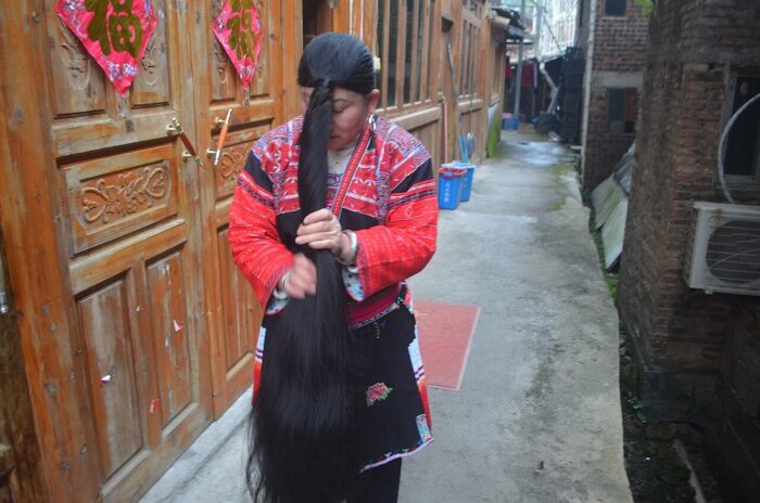 Red Yao woman shows her long hair by Bookish Worm via Wikimedia Commons