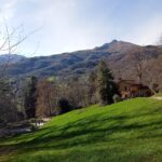 A view of the trattoria against the mountain backdrop