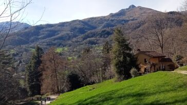 A view of the trattoria against the mountain backdrop