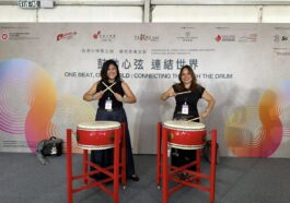 Ana Pista (right), founder and CEO of Ardent Communications, tries her hand at drumming together with a friend