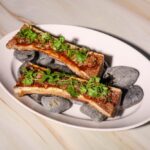 Fire-roasted beef bone marrow with nam tok tamarind vinaigrette, dried chili and in-house toasted rice cracker