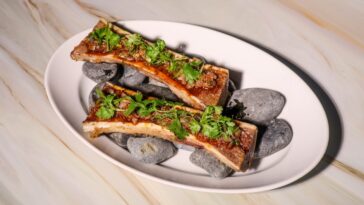 Fire-roasted beef bone marrow with nam tok tamarind vinaigrette, dried chili and in-house toasted rice cracker