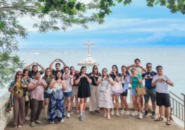 Participants pose for a photo with the Sunken Cemetery in the background