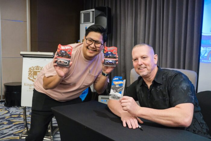 Collectors take home a personal memento as Brendon Vetuskey signs Hot Wheels memorabilia.
