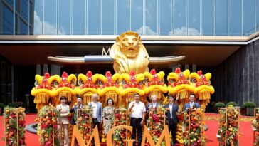 Representatives pose for a group photo during the grand opening of MGM Shenzhen Prince Bay with traditional lion dance performers.