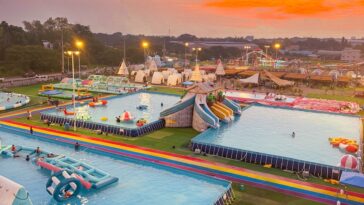 Colorful pools, playful inflatables, and exciting slides stretch across the park, offering visitors plenty of ways to cool off, have fun, and enjoy the vibrant atmosphere as the sun begins to set.