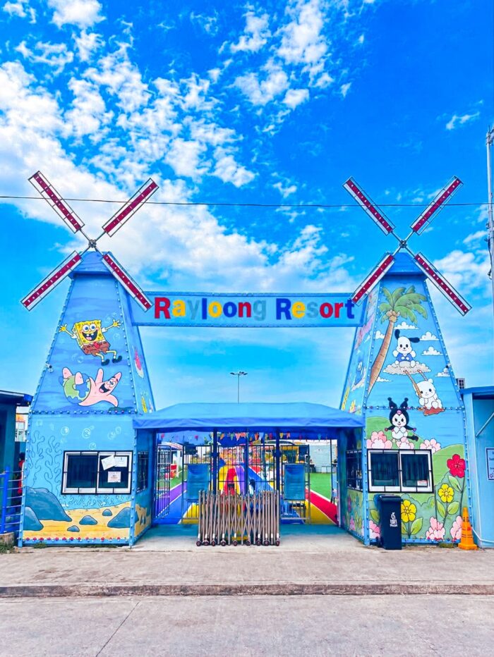 The colorful entrance of Rayloong Resort Waterfun Park welcomes visitors with its playful windmill-inspired design and vibrant cartoon murals.