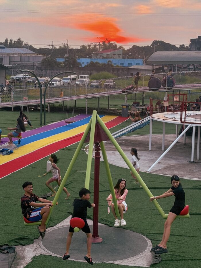 Visitors enjoy the recreational area, playing and spending time together as the sun sets.